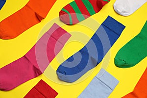 Flat lay composition of different colorful socks on yellow background