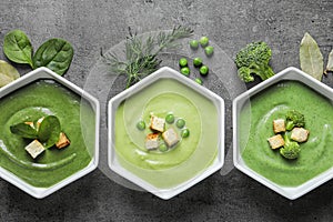 Flat lay composition with different fresh vegetable detox soups made of green peas, broccoli and spinach in dishes