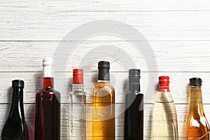 Flat lay composition with different kinds of vinegar in bottles and space for text