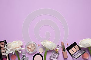 Flat lay composition with different makeup products and beautiful flowers on violet background, space for text