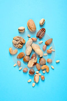 Flat lay composition with different nuts on blue background