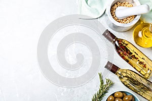 Flat lay composition with different sorts of cooking oil on marble table. Space for text