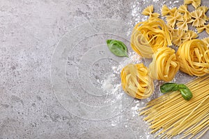 Flat lay composition with different types of pasta on background. Space for text