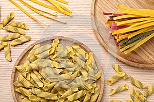 Flat lay composition with different types of pasta on wooden background