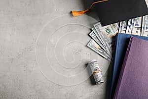Flat lay composition with dollars and student graduation hat on stone background. Tuition fees concept