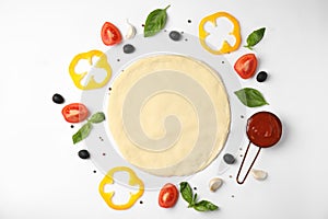 Flat lay composition with dough and ingredients for pizza on white background