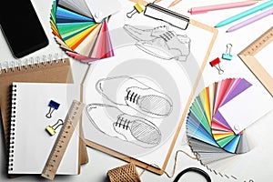 Flat lay composition with drawing of shoes on table. Designer`s workplace