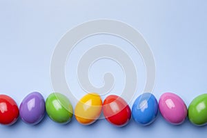 Flat lay composition with Easter eggs on color background. Frame made of decorated eggs. Top view with place for text