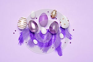 Flat lay composition with festively decorated Easter eggs on lilac background