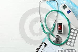 Flat lay composition with fingertip pulse oximeter and medical items on white background. Space for text