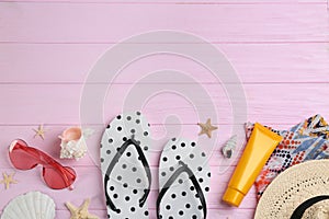 Flat lay composition with flip flops and beach accessories on pink background. Space for text