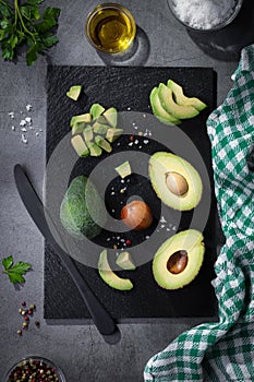 Flat lay composition with fresh avocados on dark background