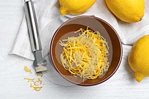 Flat lay composition with fresh lemon zest on white wooden table