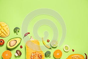 Flat lay composition with fresh organic fruits and vegetables on light green background. Space for text