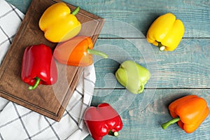 Flat lay composition with fresh ripe bell peppers on blue wooden