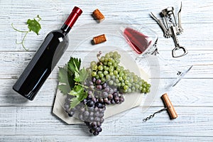 Flat lay composition with fresh ripe juicy grapes and wine on wooden table