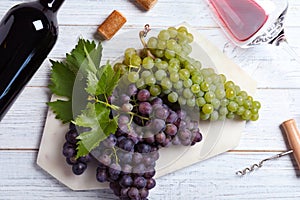 Flat lay composition with fresh ripe juicy grapes and wine on wooden table