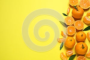 Flat lay composition with fresh ripe tangerines and leaves on background, space for text. Citrus fruit