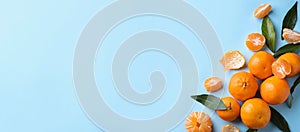 Flat lay composition with fresh ripe tangerines and leaves on light blue background, space for text. Banner design