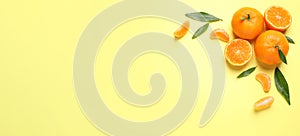 Flat lay composition with fresh ripe tangerines and leaves on light yellow background, space for text. Banner design