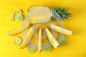 Flat lay composition with fresh sliced pineapple and lime on color wooden background