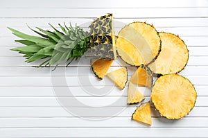 Flat lay composition with fresh sliced pineapple on wooden background