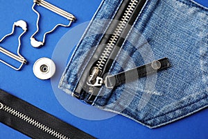 Flat lay composition with garment accessories and cutting details for jeans on background