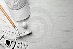 Flat lay composition with golf accessories on white wooden background