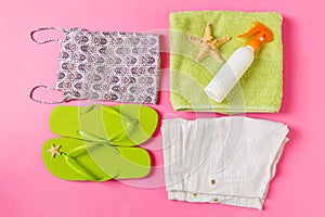 Flat lay composition with green Beach accessories on pink or coral color background. Summer holiday background. Vacation and