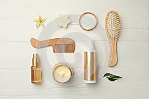 Flat lay composition with hair care cosmetic products on white wooden table