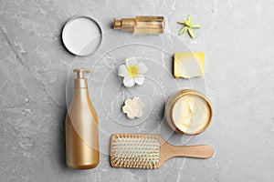 Flat lay composition with hair cosmetic products on grey marble table