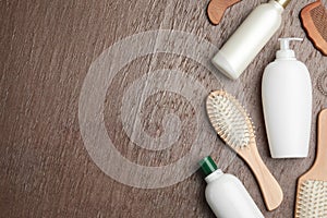 Flat lay composition with hair cosmetic products and tools on brown background