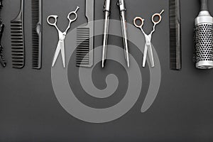 Flat lay composition with Hairdresser tools: scissors, combs, hair iron on black background with copy space for text. Frame.