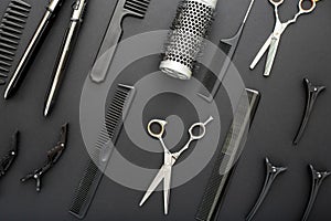 Flat lay composition with Hairdresser tools: scissors, combs, hair iron on black background. Frame. Hairdresser service. Beauty