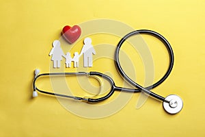 Flat lay composition with heart, stethoscope and paper silhouette of family on color background. Life insurance