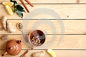 Flat lay composition of herbal tea, tea accessories, honey, spoon of dried tea, plant leaves, ginger root, lemon. Border frame, vi