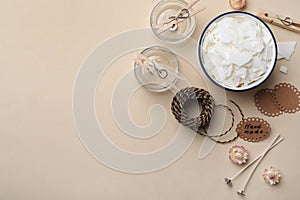 Flat lay composition with homemade candles ingredients on beige background, space for text