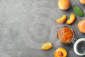 Flat lay composition with jar of tasty peach jam and fresh fruit