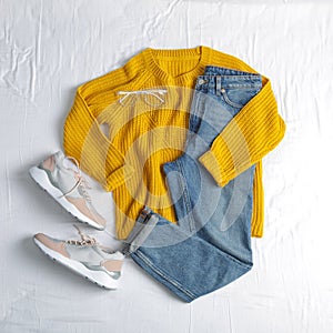 Flat lay composition with jeans, sweater and shoes