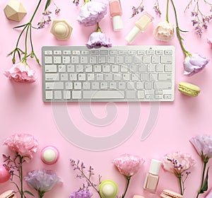 Flat lay composition with keyboard and flowers. Beauty blogger`s workplace
