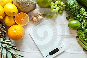 Flat lay composition with kitchen scales, healthy vegetables and fruit on wooden background. Weight loss diet