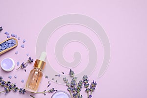 Flat lay composition with lavender flowers and natural cosmetic products on pink background. Space for text