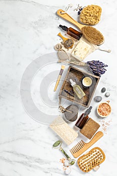 Flat lay composition with lavender flowers and natural cosmetic products on white marble background
