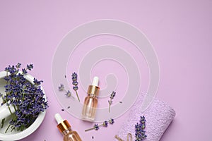 Flat lay composition with lavender flowers and natural essential oil on background. Space for text