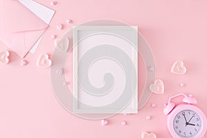 Flat lay composition made of alarm clock, heart shaped candles, envelope with letter