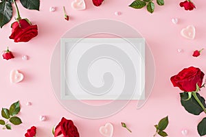 Flat lay composition made of red roses with leaves and heart shaped candles