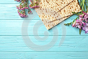 Flat lay composition of matzo and flowers on wooden background. Passover Pesach Seder