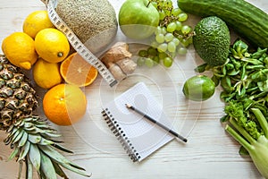 Flat lay composition with measuring tape, healthy vegetables and fruit on wooden background. Weight loss diet