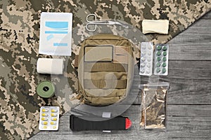 Flat lay composition with military first aid kit on wooden table
