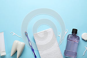 Flat lay composition with mouthwash and other oral hygiene products on light blue background. Space for text